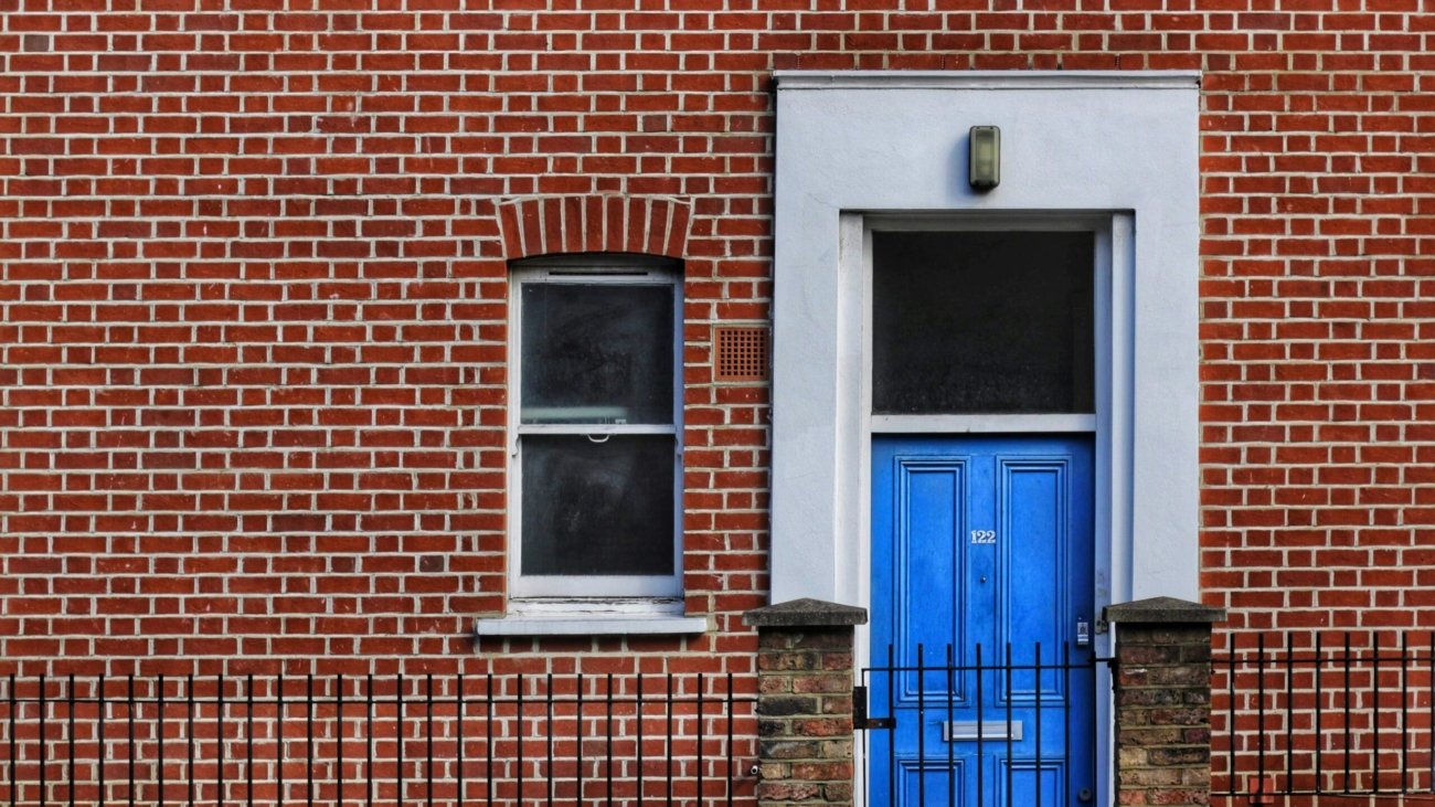 red brick building with closed door and window